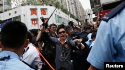 اتوار کو ہونے والے مظاہرے کے دوران پولیس اور مظاہرین کے درمیان ہاتھا پائی کا ایک منظر