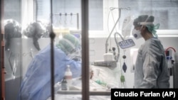 In this Thursday, March 19, 2020, file photo, medical personnel work in the intensive care unit of a hospital in Brescia, Italy. World War II references are now heard daily because of the coronavirus crisis. (Claudio Furlan/LaPresse via AP, File)