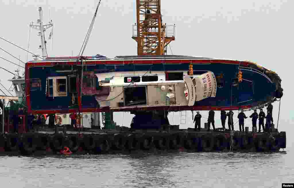 A capsized fishing boat is lifted during its salvation operation in the sea off Incheon, South Korea.