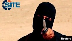 FILE - A masked, black-clad militant, who has been identified by the Washington Post newspaper as a Briton named Mohammed Emwazi, brandishes a knife in this still image from a 2014 video obtained from SITE Intel Group.