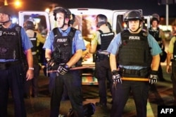 FILE - Police are deployed during a civil disobedience action in Ferguson, Missouri, Aug. 10, 2015. A recent report shows that, in hundreds of U.S. police departments, the percentage of white police officers is more than 30 percent higher than populations in the communities they serve.