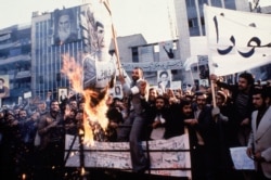 FILE - In an undated photo from 1979, protestors burn an effigy of Shah Mohammad Reza Pahlavi during a demonstration in front of the U.S. Embassy in Tehran, Iran.