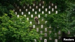 Vojnik postavlja američke zastavice na grobove vojnika - kojih na Nacionalnom groblju u Arlingtonu ima više od 260.000, fotografisano 25. maja 2023. godine.