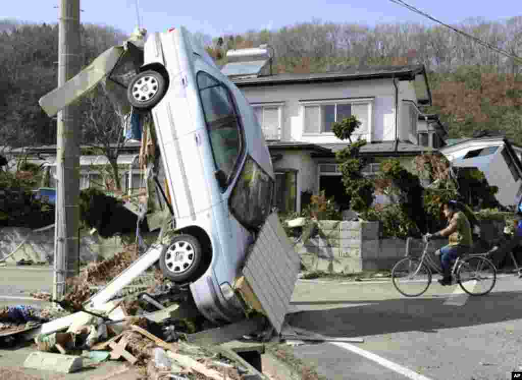 A car swept by a tsunami is overturned on the street in Miyako City, Iwate Prefecture. (Reuters Image)