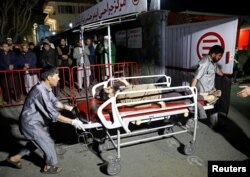 Hospital workers carry an injured person to a hospital after a suicide attack in Kabul, Afghanistan, Nov. 20, 2018.