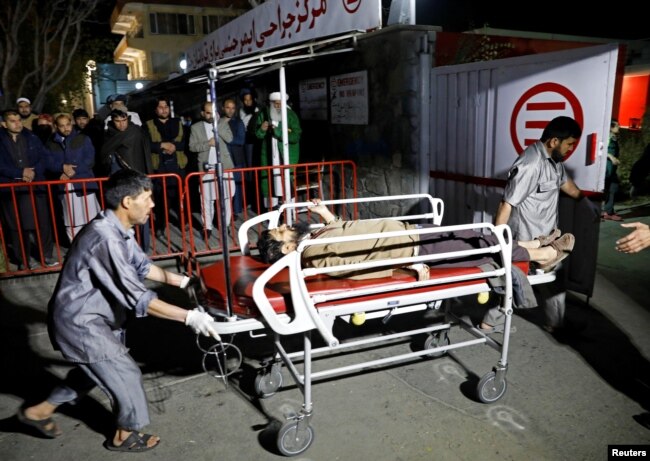 Hospital workers carry an injured person to a hospital after a suicide attack in Kabul, Afghanistan, Nov. 20, 2018.