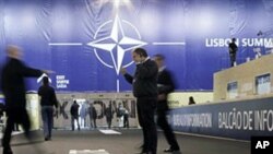 Journalist walk inside the media center at the NATO summit venue in Lisbon, 18 Nov 2010