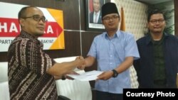 Juru bicara Forluni UNJ Ide Bagus Arif berpeci hitam menyerahkan data terkait kasus plagiarisme di UNJ kepada anggota komisi X DPR RI Dadang Rusdiana. (Foto dokumentasi: Forluni UNJ).