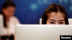 Government staff work as they monitor social media in a social media war room in Bangkok, Thailand, March 8, 2019. 