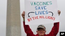 Ben Prickril poses for a portrait with a sign that reads "Vaccines Save Lives By The Millions" at the March for Science event in Washington, April 22, 2017.