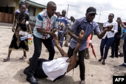 A relative, carried by two men, reacts to the death of a man who succumbed to a gunshot wound he sustained during a protest called by the Catholic Church, to push for Democratic Republic of Congo President Joseph Kabila to step down, in Kinshasa, Democratic Republic of Congo, Feb. 25, 2018.