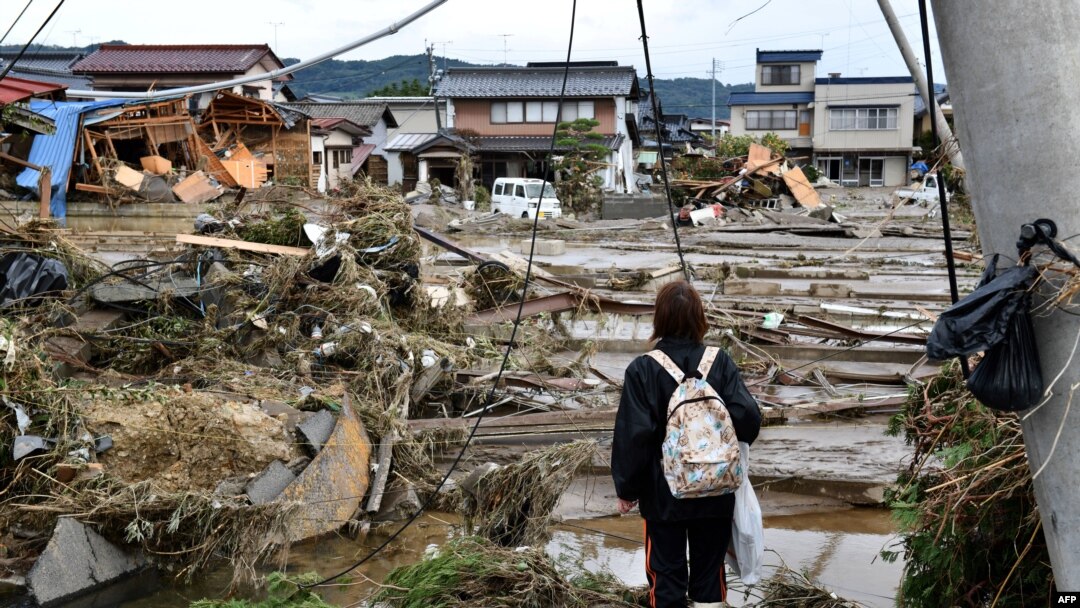 Seorang wanita melihat rumah-rumah yang rusak akibat banjir di Nagano pada 15 Oktober 2019, setelah Topan Hagibis melanda Jepang pada 12 Oktober 2019. (Foto: AFP)