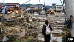 Seorang wanita melihat rumah-rumah yang rusak akibat banjir di Nagano pada 15 Oktober 2019, setelah Topan Hagibis melanda Jepang pada 12 Oktober 2019. (Foto: AFP)