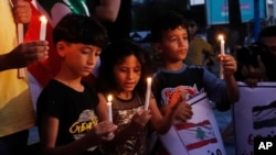 Palestinian children light candles to show their solidarity with the Lebanese people following the explosion in the port of Beirut, at the unknown soldier square in Gaza City, Aug. 6, 2020.