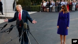 First lady Melania Trump looks on as President Donald Trump speaks with reporters before departing from the White House on a trip to Asia, Nov. 3, 2017, in Washington.