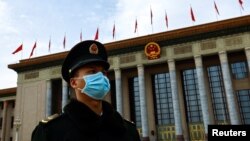 FILE - A paramilitary police officer stands guard outside the Great Hall of the People, in Beijing, China, March 13, 2023.