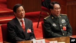 FILE- Xu Caihou, vice chairman of the CPC Central Military Commission, right, and Chongqing party secretary Bo Xilai attend the closing session of the National People's Congress in Beijing's Great Hall of the People in China, March 14, 2012.