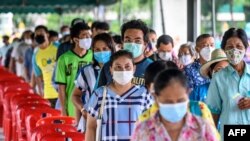 지난 24일 태국 방콕의 한 사원에서 마스크를 쓴 주민들이 신종 코로나바이러스 사태 지원금을 받기 위해 줄 서 있다.