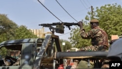 Des soldats patrouillent à bord de leur camion militaire à l'entrée d'un bureau de vote à la mairie de Niamey lors du second tour de l'élection présidentielle, le 20 mars 2016. AFP PHOTO / ISSOUF SANOGO