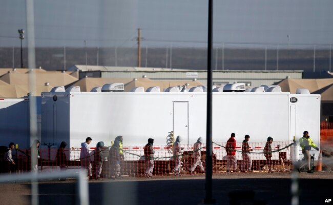 Migrant teens walk in a line through the Tornillo detention camp in Tornillo, Texas, Thursday, Dec. 13, 2018.