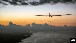 FILE - In this photo provided by Jean Revillard, Solar Impulse 2, a plane powered by the sun's rays and piloted by Andre Borschberg, approaches Kalaeloa Airport near Honolulu, July 3, 2015. 