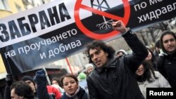 FILE - Protesters shout slogans and carry a banner that reads "Ban shale gas tests through hydraulic fracturing" during a rally in central Sofia, January 14, 2012. 