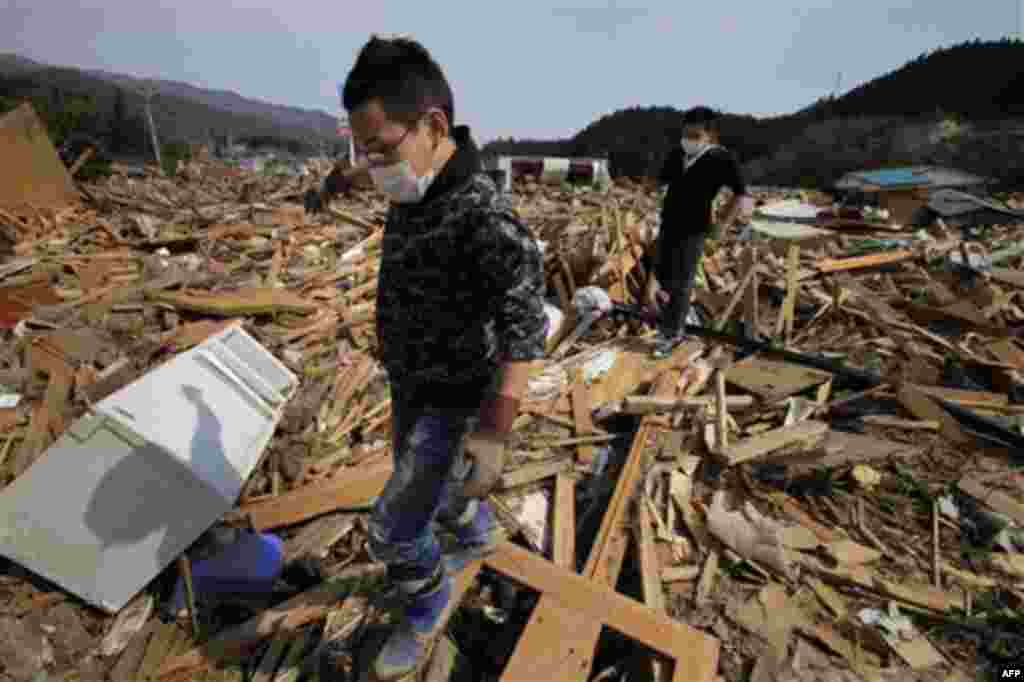 Local people search their destroyed houses in Rikuzentakata, Iwate Prefecture, northern Japan, Monday, March 14, 2011, three days after northeastern coastal towns were devastated by an earthquake and tsunami. (AP Photo/Itsuo Inouye)