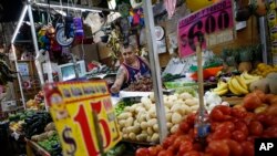 El vendedor Luis Alberto Bautista organiza fresas mientras prepara productos frescos al inicio del día en el Mercado Medellín, en Ciudad de México, el 2 de febrero de 2017. México México llegó a un nuevo acuerdo de libre comercio con la Unión Europea el sábado.