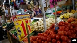 Vendor Luis Alberto Bautista arranges strawberries as he lays out fresh produce at the start of the day in Mercado Medellin, in Mexico City, Feb. 2, 2017. Mexico is the world’s leading exporter of refrigerators and flat-screen TVs, berries, vegetables and other produce. Mexico reached a new free trade agreement with the European Union on Saturday.