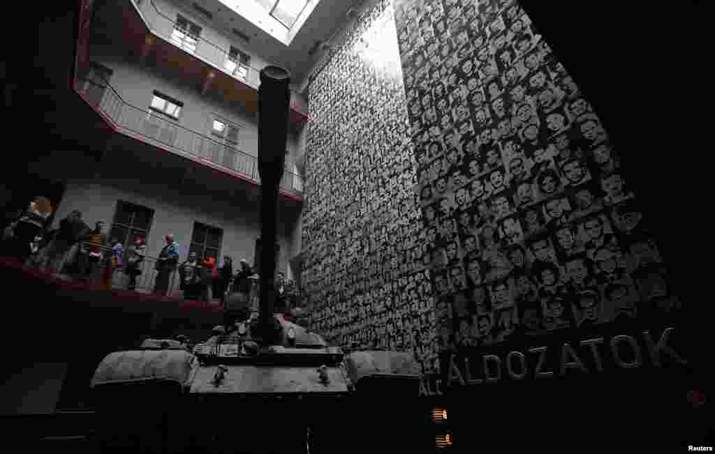 A Soviet-made T34 tank is seen in front of pictures of the victims of communist dictatorship during the memorial day of the communist victims at the House of Terror Museum in Budapest, Hungary. 