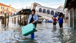 ຜູ້ຄົນພວມລຸຍນ້ຳໃກ້ໆຂົວ Rialto Bridge ໃນນະຄອນເວນິສ ປະເທດອີຕາລີ ເມື່ອວັນທີ 23 ທັນວາ 2019.