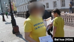 (FILE) A practitioner from Falun Gong distributes materials in Arbat street in Moscow center, summer, 2013. 