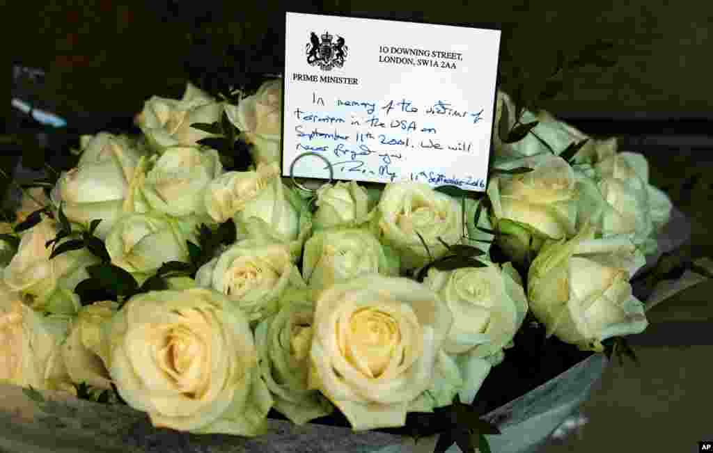 A hand written note from the British Prime Minister Theresa May rests on a bouquet of roses paying respects to the victims of the attacks of the World Trade Center in New York, on the 15th anniversary of the attacks, at the memorial to the British victims of the attacks in Grosvenor Square gardens near the United States Embassy in London, Sept. 11, 2016.
