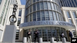 FILE - Heavily armed U.S. Marshals stand guard outside the federal court, April 2, 2015, in the Brooklyn borough of New York. 
