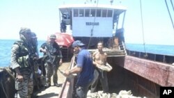 Handout photo shows members of Philippine Army inspecting one of eight Chinese fishing boats spotted in the Scarborough Shoal, a small group of rocky formations whose sovereignty is contested by the Philippines and China, in the South China Sea, about 124