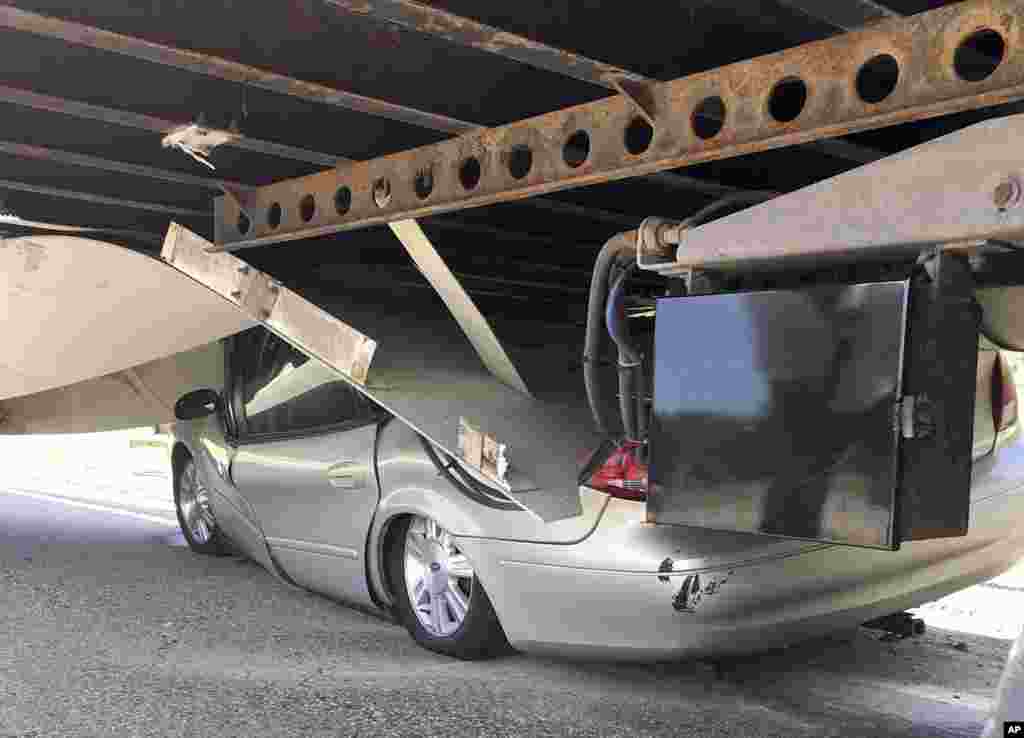 In this photo released by the Uxbridge Fire Department on its Facebook page, a car sits wedged under a tractor-trailer on Route 146 in Uxbridge, Massachusetts. The motorist, whose name wasn&#39;t made public, climbed out of the driver&#39;s side door of the crushed car and wasn&#39;t seriously hurt.