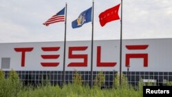 Flags fly over the Tesla Gigafactory 2, which is also known as RiverBend, a joint venture with Panasonic to produce solar panels and roof tiles in Buffalo, New York, Aug. 2, 2018. 