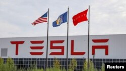 Flags fly over the Tesla Inc. Gigafactory 2, which is also known as RiverBend, a joint venture with Panasonic to produce solar panels and roof tiles in Buffalo, New York, U.S., Aug. 2, 2018. 