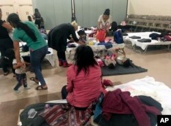 FILE - Guatemalan migrant Cirila Alejandra Calelpu, 20, sitting, rests at the Cathedral of the Immaculate Heart of Mary migrant shelter in Las Cruces, N.M., after she and her 3-year-old daughter were released from U.S. Immigration and Customs Enforcement detention, Nov. 29, 2018.