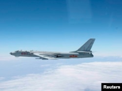 A Chinese military plane H-6 bomber flies through airspace between Okinawa prefecture's main island and the smaller Miyako island in southern Japan, out over the Pacific, in this handout photo taken Oct. 27, 2013 by Japan Air Self-Defence Force.