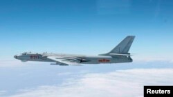 中国军机H-6轰炸机在日本南部冲绳主岛与小宫岛之间飞行。 （日本自卫队 2013年10月27日拍摄）