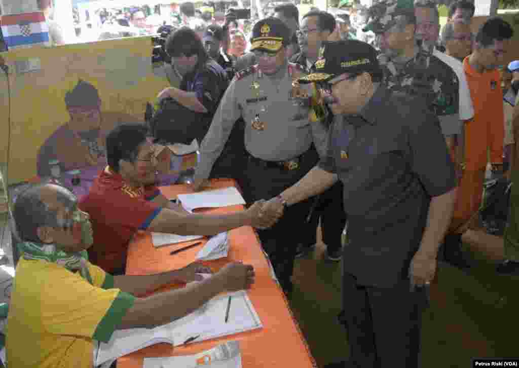 Gubernur Jawa Timur Soekarwo (bersalaman), Kapolda Jawa Timur Irjen Pol. Machfud Arifin (tengah), Pangdam V/Brawijaya Mayjen Arif Rahman (belakang), serta Ketua KPU Jawa Timur Eko Sasmito, mengunjungi TPS 06 di Kelurahan Kebonsari, Kecamatan Jambangan, dalam pelaksanaan pilkada serentak, 27 Juni 2018. (Foto: Petrus Riski/VOA)