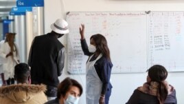 FILE - A health worker talks to a vaccine trials' volunteer in Johannesburg, South Africa, August 27, 2020. (REUTERS/Siphiwe Sibeko)
