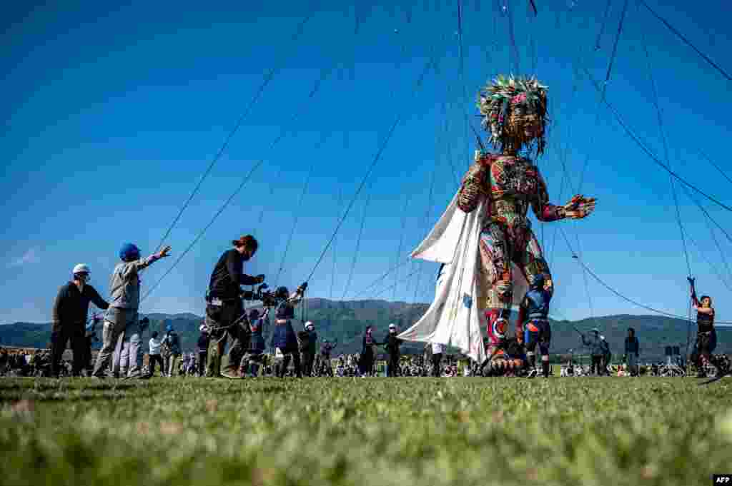 Performers control &#39;MOCCO&#39;, a giant puppet designed by Noriyuki Sawa during the &quot;Rediscover Tohoku - MOCCO&#39;s Journey from Tohoku to Tokyo&quot; media tour at Takata Matsubara Tsunami Reconstruction Memorial Park in Rikuzentakata, Japan, May 15, 2021.