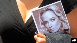 Umufasoni avuye ku maziko afise ifoto ya Reeva Steenkamp, yarashwe na Pistorius, 
