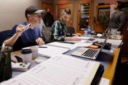 In this Oct. 21, 2019, photo, composer Gordy Haab, left, oversees the recording of his video game soundtrack with the help of Sam Smythe, center, in Nashville, Tenn.