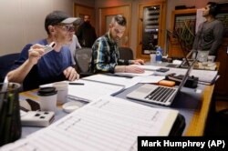 In this Oct. 21, 2019, photo, composer Gordy Haab, left, oversees the recording of his video game soundtrack with the help of Sam Smythe, center, in Nashville, Tenn.