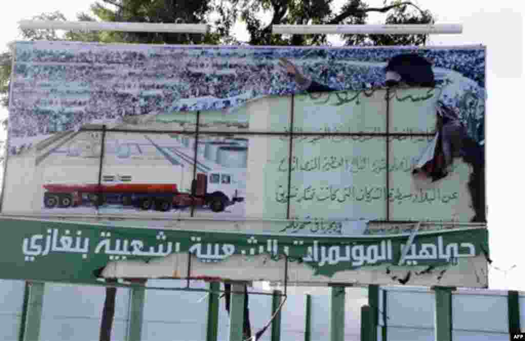 This photograph, obtained by The Associated Press outside Libya and taken by an individual not employed by AP, shows a scene from recent days' unrest in Benghazi, Libya. Writing in arabic in white on green at base of torn government banner showing Libyan 