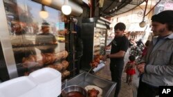 A man buys food in the city of Idlib, Syria, March 9, 2020 during the truce, brokered by Turkey and Russia, which halted a terrifying three-month air and ground campaign by the Syrian government against the rebel-held province.