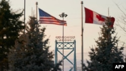 Zastave Amerike i Kanade na kanadskoj strani Ambasador mosta u Vindzoru, jednog od graničnih prelaza u kanadskoj državi Ontario (Foto: AFP/Geoff Robins)
